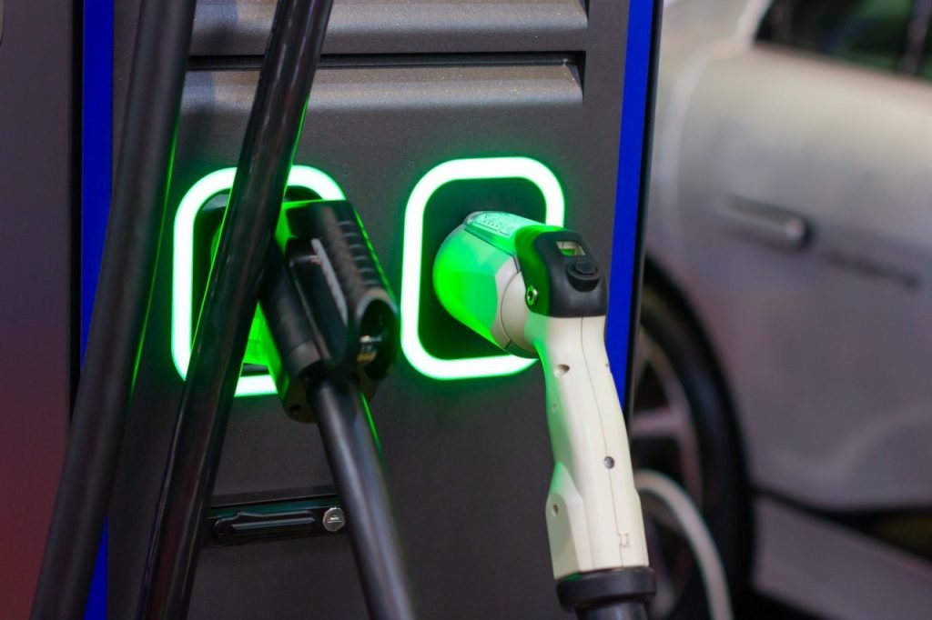 Close-up of a modern electric vehicle fast charger with illuminated charging ports.